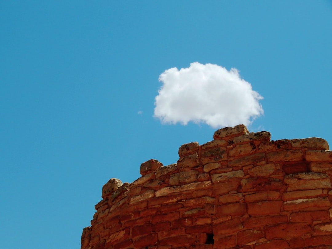 A single cloud floats above ancient stone ruins.