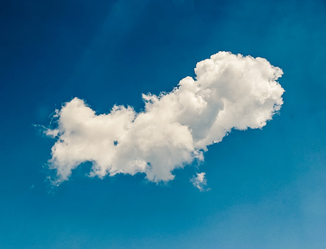 a white cloud floating in a blue sky