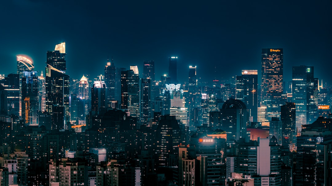 Skyscrapers illuminated at night in a sprawling cityscape.