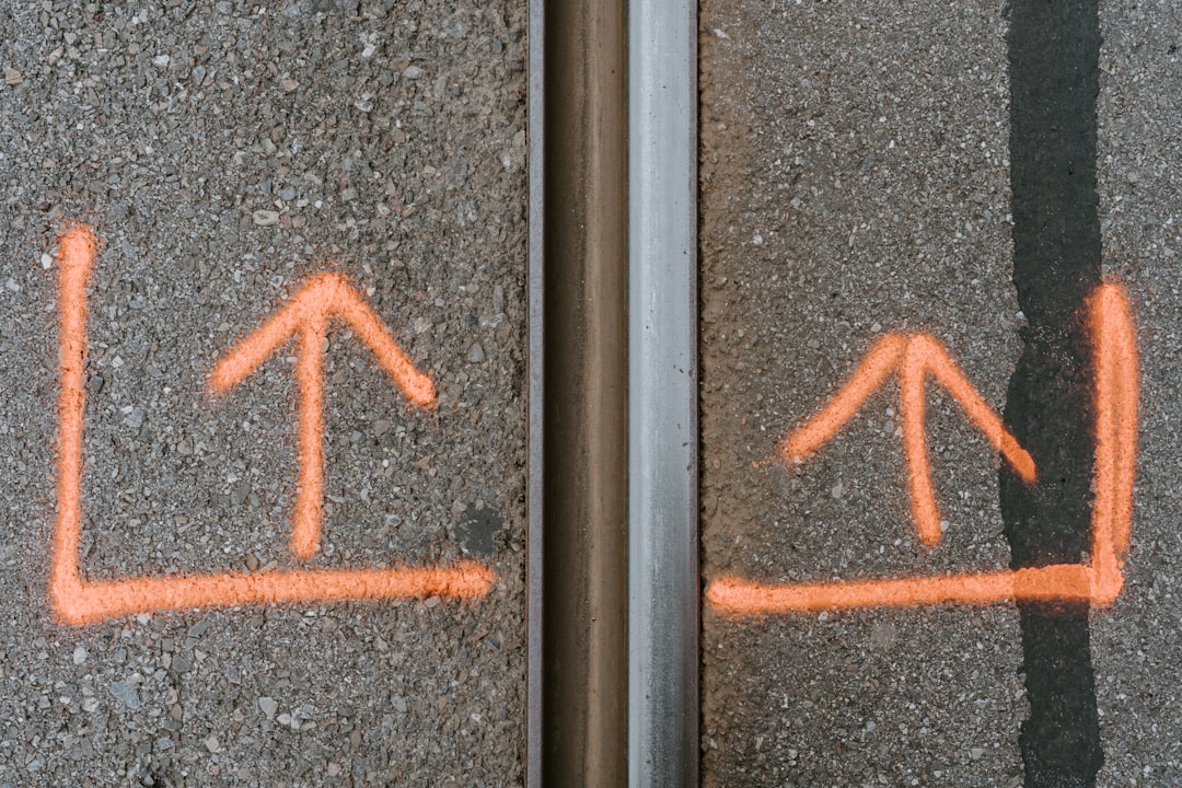 gray concrete pavement with orange arrow