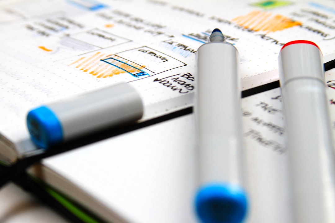 a couple of pens sitting on top of a notebook