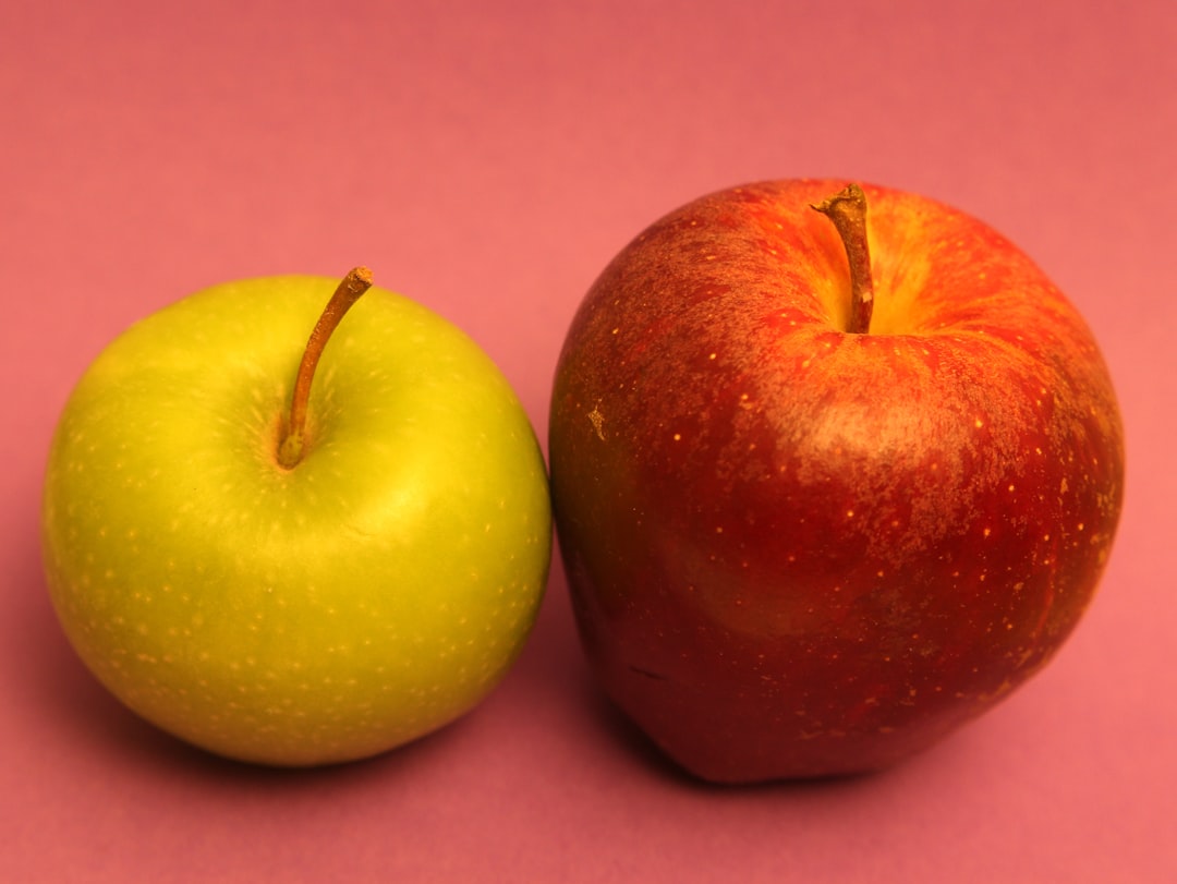 A green and red apple sit side by side.
