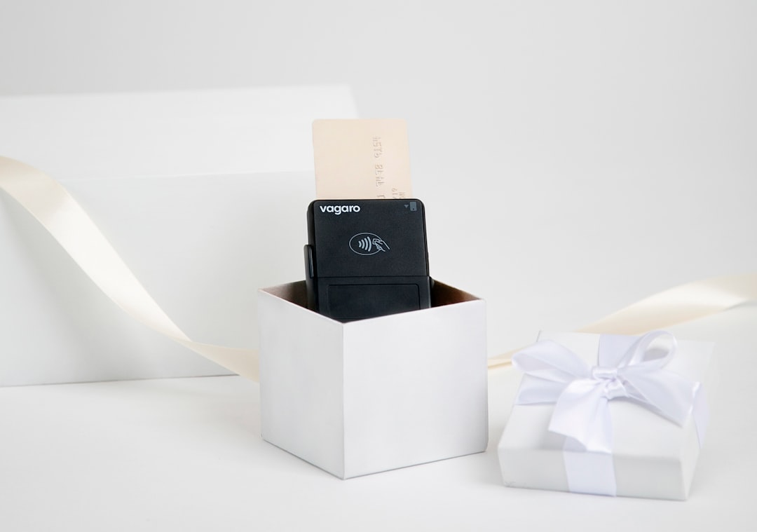 Black device in a white gift box with ribbon