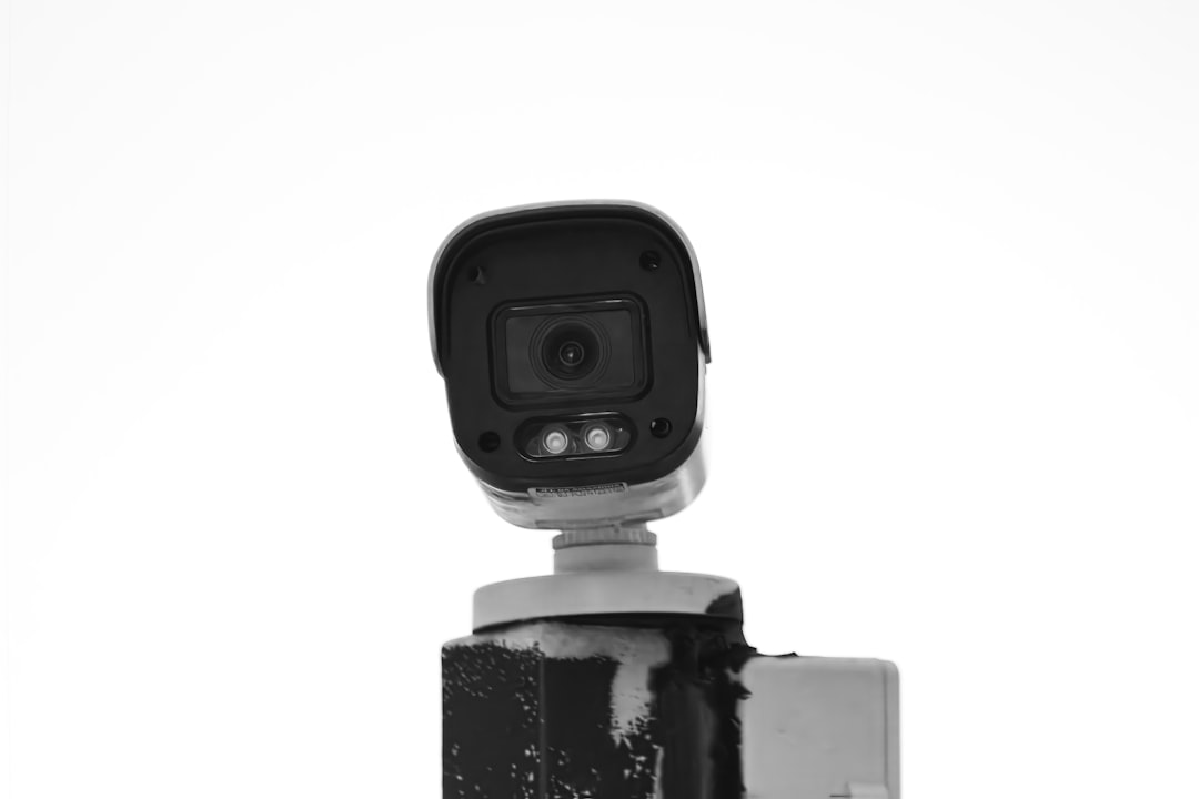 Security camera mounted on a post against a white background