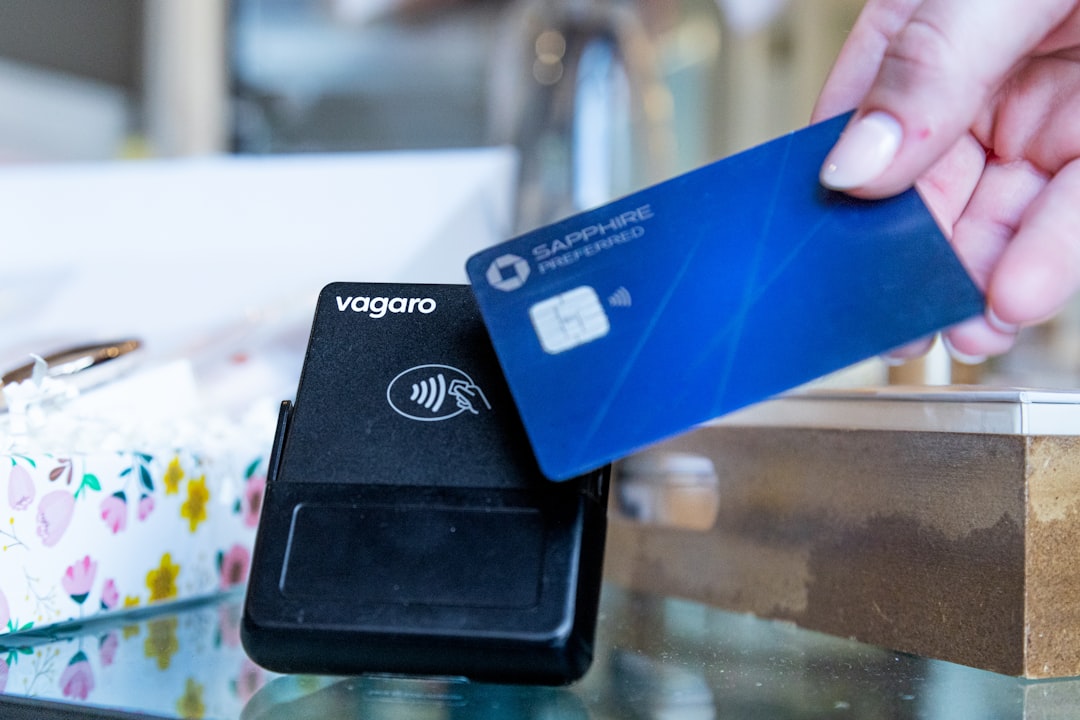 Hand holding credit card near payment terminal